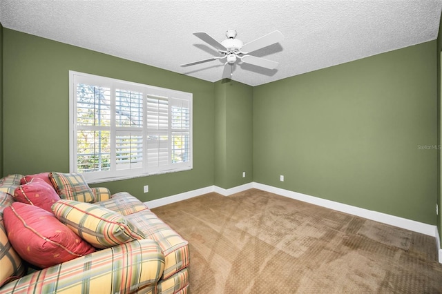 living area featuring carpet flooring, ceiling fan, and a textured ceiling