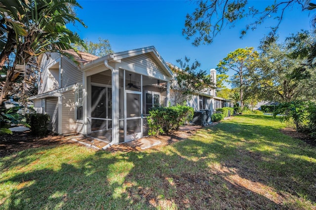 back of property featuring a sunroom and a yard