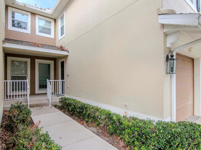 property entrance with a porch and a garage