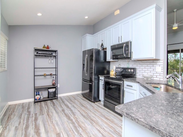 kitchen with sink, stainless steel appliances, light hardwood / wood-style floors, lofted ceiling, and white cabinets