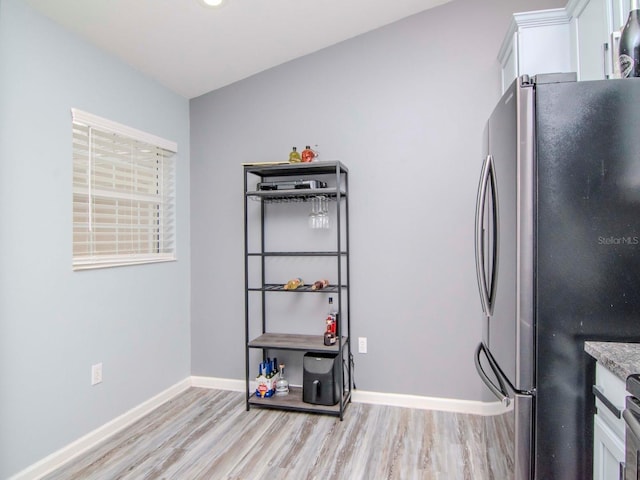 kitchen featuring stainless steel refrigerator, white cabinets, and light wood-type flooring