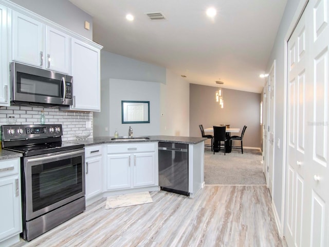 kitchen with kitchen peninsula, sink, white cabinetry, and stainless steel appliances