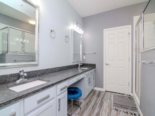 bathroom featuring a shower with shower door, wood-type flooring, and vanity