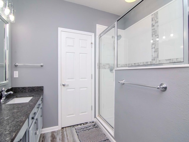 bathroom featuring hardwood / wood-style floors, vanity, and walk in shower