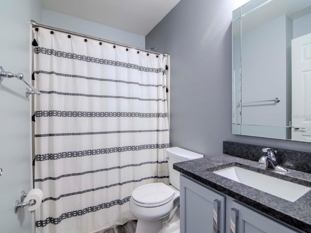 bathroom with a shower with curtain, vanity, and toilet