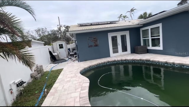 back of house featuring french doors and a storage shed