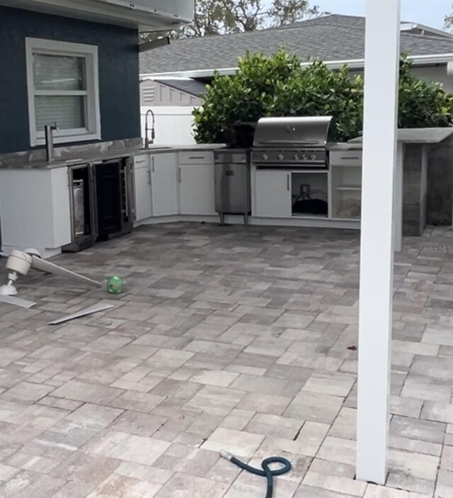 view of patio with sink, wine cooler, area for grilling, and a grill