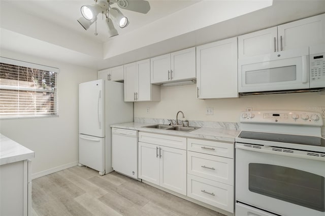 kitchen featuring white appliances, white cabinets, sink, light hardwood / wood-style flooring, and ceiling fan