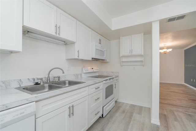 kitchen featuring white appliances, sink, light hardwood / wood-style flooring, a notable chandelier, and white cabinets