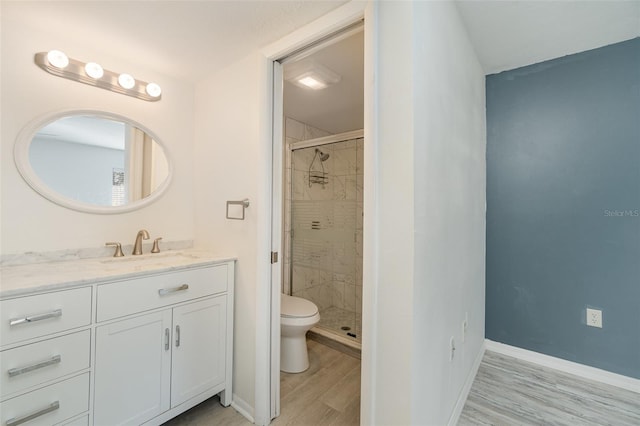 bathroom featuring vanity, hardwood / wood-style flooring, toilet, and walk in shower