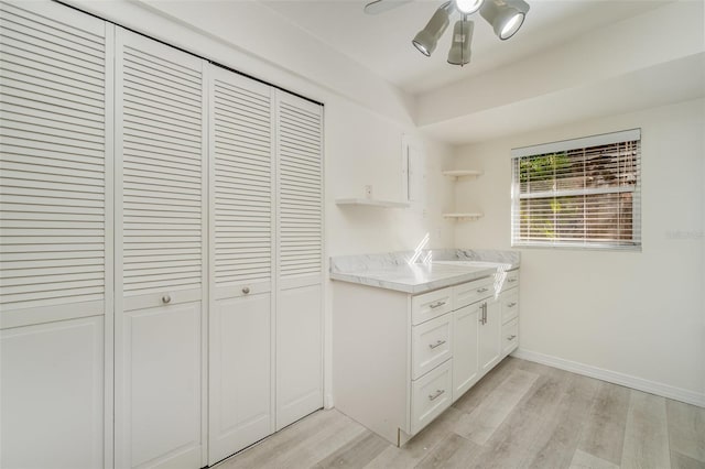 kitchen with ceiling fan, white cabinets, and light hardwood / wood-style floors