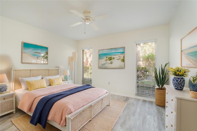 bedroom with ceiling fan, light hardwood / wood-style floors, and multiple windows