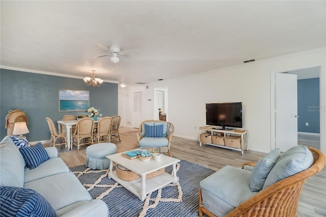 living room with crown molding, ceiling fan with notable chandelier, and light wood-type flooring