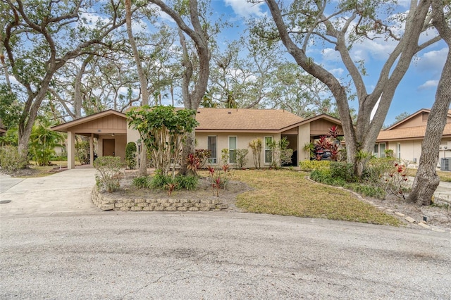 single story home with cooling unit and a carport