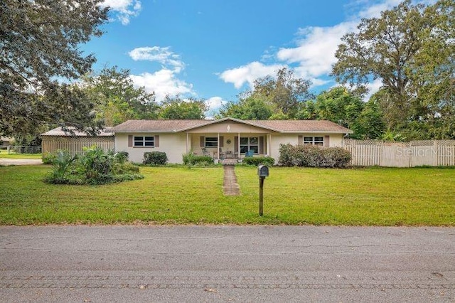 ranch-style home with a porch and a front lawn