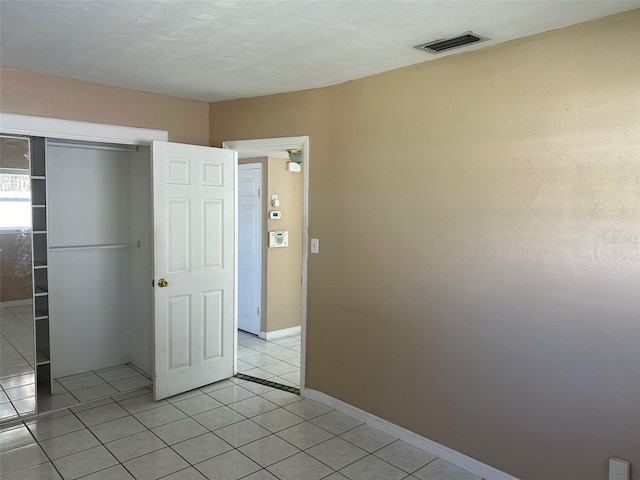 unfurnished bedroom featuring a closet and light tile patterned flooring