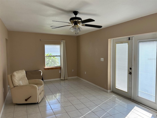 unfurnished room with ceiling fan and light tile patterned flooring