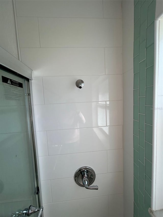 interior details featuring a tile shower