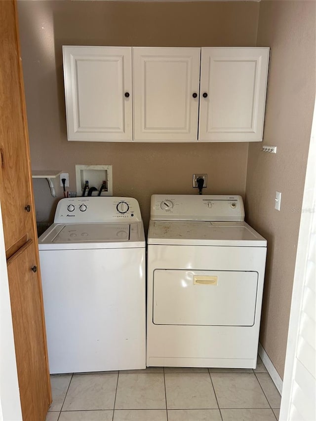 laundry area featuring cabinets, independent washer and dryer, and light tile patterned floors