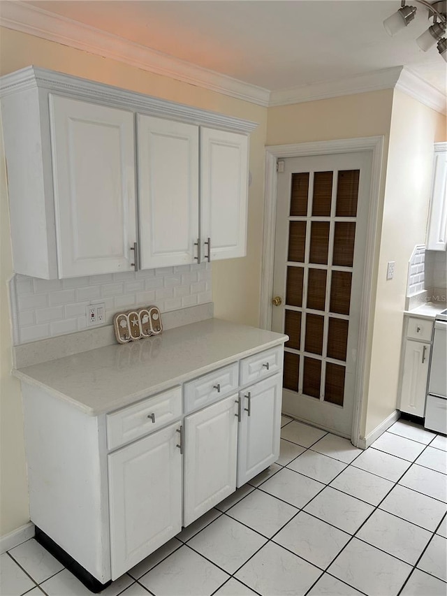 10170 64th Ave, Seminole, FL 33772 - kitchen featuring decorative backsplash, white cabinetry, light countertops, light tile patterned flooring, and ornamental molding