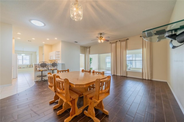 dining space with dark hardwood / wood-style flooring, ceiling fan, and plenty of natural light