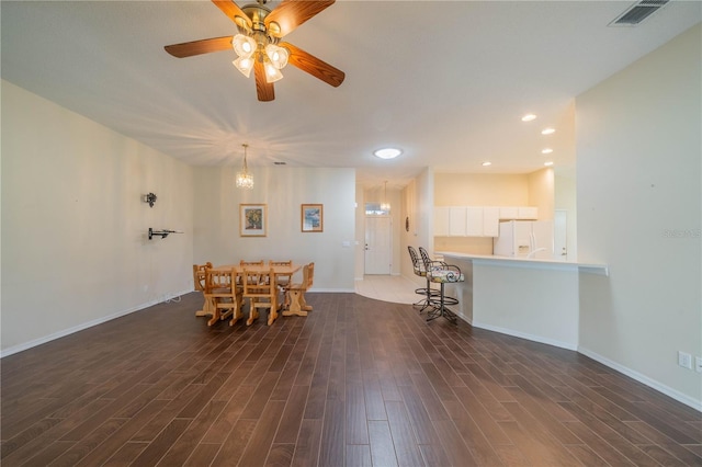 dining room featuring dark hardwood / wood-style floors and ceiling fan with notable chandelier