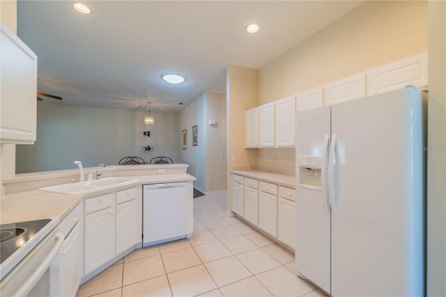 1257 Corinth Greens Dr Unit 1257, Sun City Center, FL 33573 - kitchen with white appliances, a sink, a peninsula, white cabinetry, and light tile patterned floors