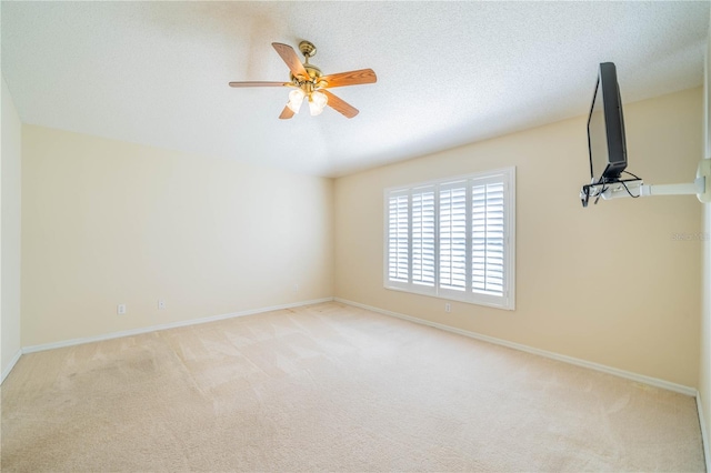 spare room featuring a textured ceiling, light colored carpet, and ceiling fan