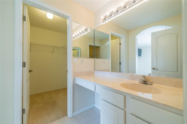 1257 Corinth Greens Dr Unit 1257, Sun City Center, FL 33573 - bathroom with vanity, a spacious closet, tile patterned floors, and baseboards
