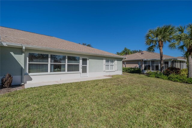 1257 Corinth Greens Dr Unit 1257, Sun City Center, FL 33573 - rear view of property featuring stucco siding and a yard