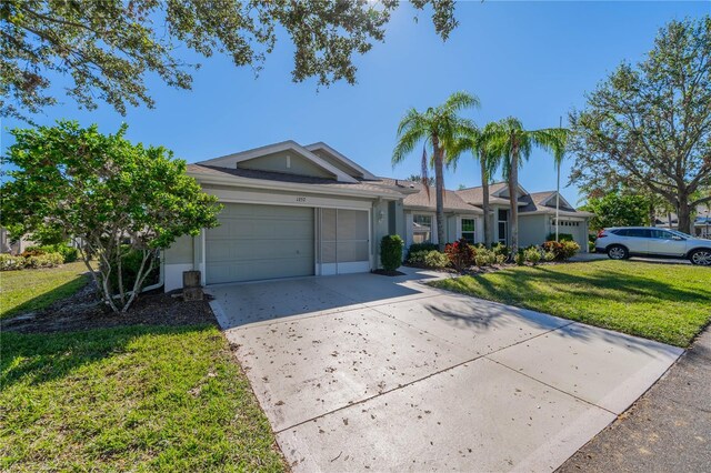 1257 Corinth Greens Dr Unit 1257, Sun City Center, FL 33573 - ranch-style home featuring driveway, an attached garage, a front lawn, and stucco siding