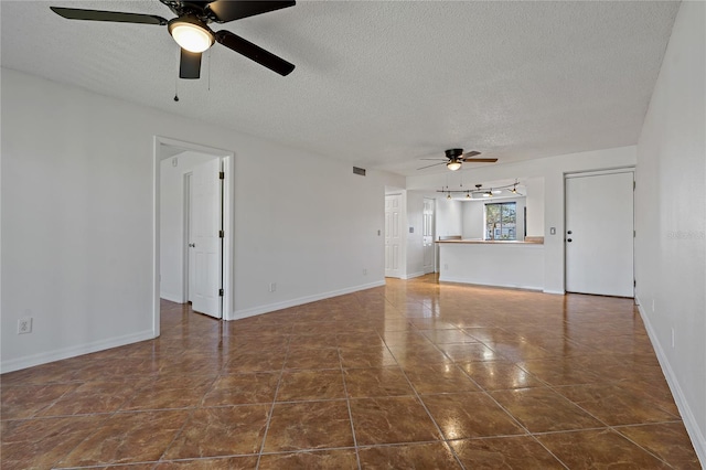 unfurnished living room featuring a textured ceiling, dark tile patterned flooring, and ceiling fan