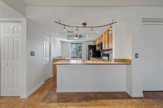 kitchen with black appliances, ceiling fan, kitchen peninsula, and sink