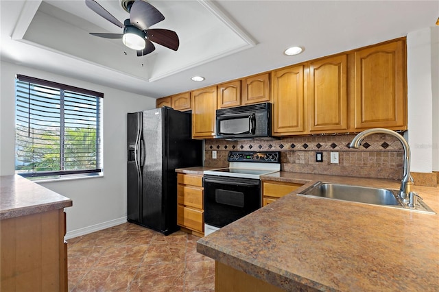 kitchen featuring ceiling fan, sink, backsplash, a tray ceiling, and black appliances