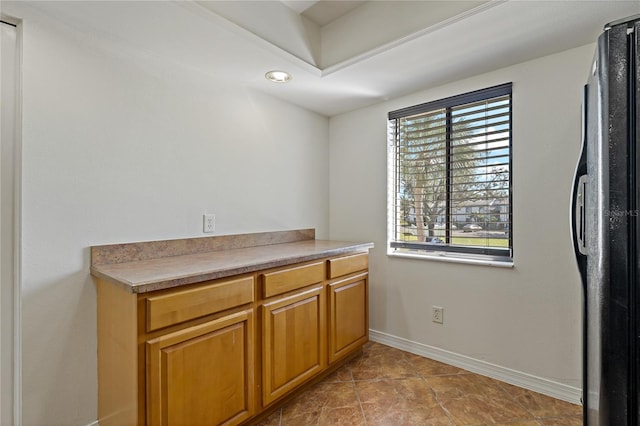 kitchen with black refrigerator and light tile patterned floors