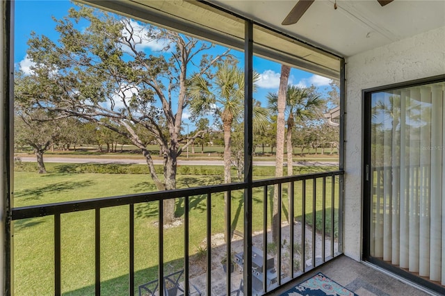 unfurnished sunroom with ceiling fan