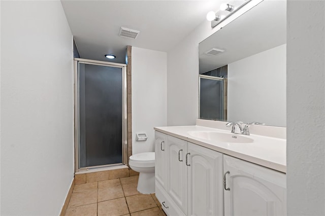 bathroom featuring tile patterned flooring, vanity, toilet, and an enclosed shower