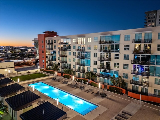 pool at dusk with a patio