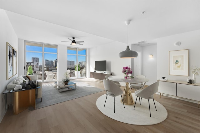 dining area featuring floor to ceiling windows, ceiling fan, and wood-type flooring