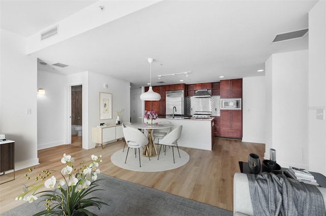 dining area featuring sink and light wood-type flooring