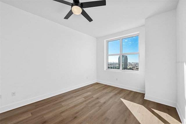 spare room with hardwood / wood-style floors and ceiling fan