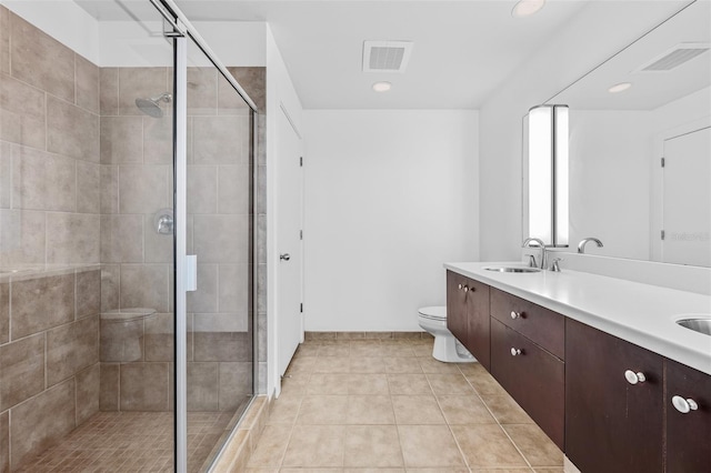 bathroom with tile patterned floors, vanity, toilet, and a shower with shower door