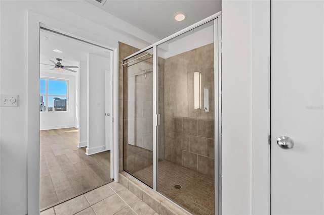 bathroom with tile patterned flooring, ceiling fan, and a shower with door