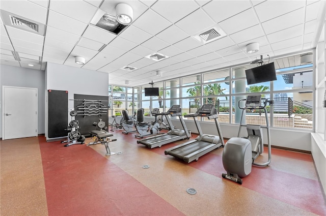 gym with a paneled ceiling and a wealth of natural light