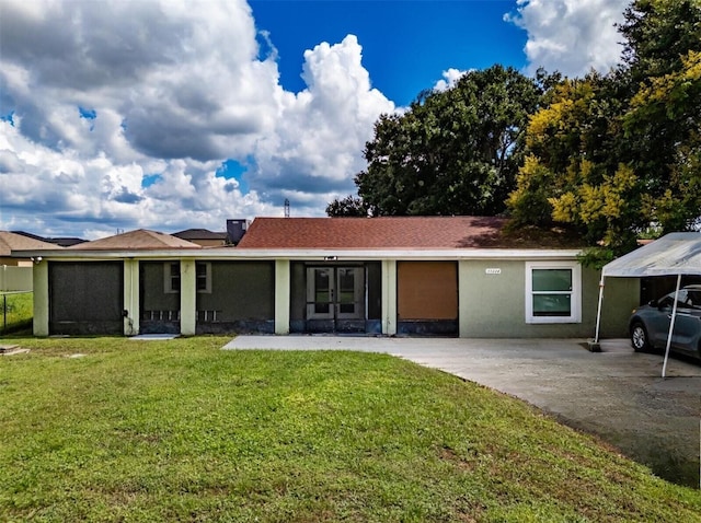 view of front of property featuring a front yard and a carport