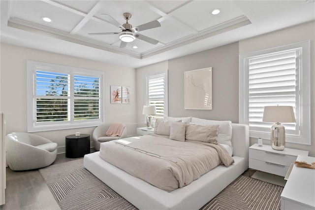 bedroom with hardwood / wood-style flooring, crown molding, ceiling fan, and coffered ceiling