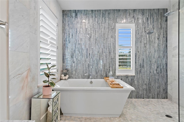 bathroom with tile walls and independent shower and bath