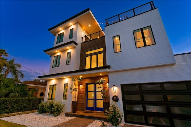 contemporary house with a garage and a balcony