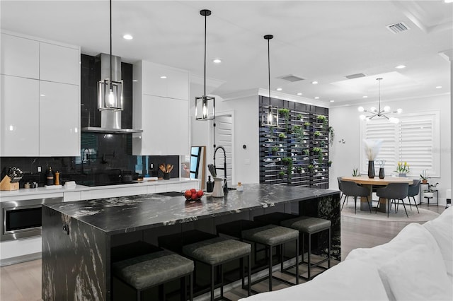 kitchen featuring white cabinets, a kitchen bar, and a spacious island