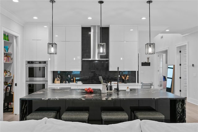 kitchen with a kitchen bar, a large island with sink, and exhaust hood